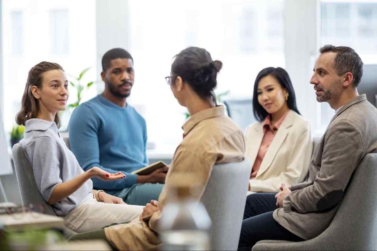 A diverse group of people engaged in conversation while sitting in a circle.