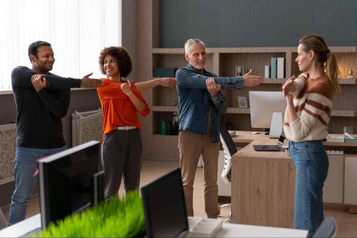 A group of diverse office workers joyfully dancing together in a bright, modern workspace.