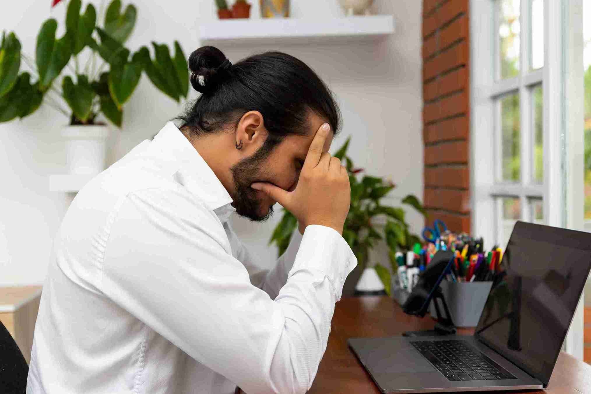 side view young man using mobile phone while sitting table